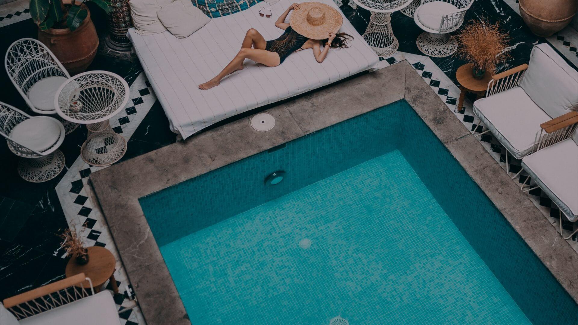 Woman relaxing on poolside lounge chair beside clean residential swimming pool in Brentwood CA